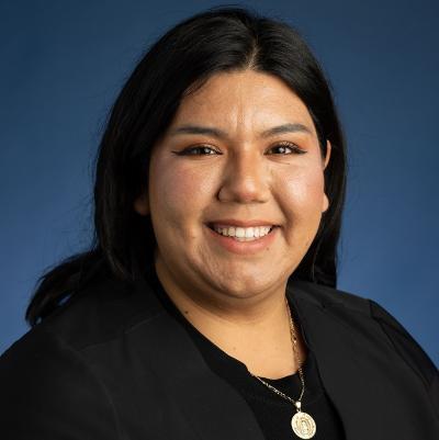 A headshot of a woman in front of a blue background